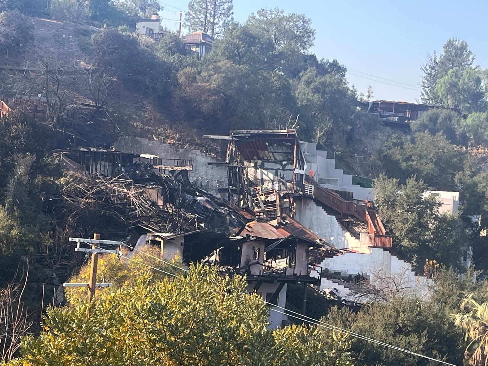 Damaged hillside structures and burned vegetation after the Sunswept Fire in Studio City.